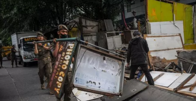 Maraknya aktivitas bangli (bangunan liar) di Jalur Lingkar Selatan (JLS) Cilegon menjadi perhatian serius bagi pemerintah daerah dan masyarakat. Hal ini bukan hanya berpotensi menimbulkan masalah estetika dan lingkungan, tetapi juga dapat mengganggu ketertiban umum. Dalam konteks ini, DPRD Cilegon mengusulkan pembentukan Satuan Tugas (Satgas) Penertiban untuk menangani fenomena bangli yang semakin meluas. Usulan ini diharapkan dapat mengatasi masalah yang ada dan menciptakan lingkungan yang lebih teratur dan tertib. Artikel ini akan membahas lebih dalam mengenai isu bangli di JLS, latar belakang usulan DPRD, langkah-langkah yang diambil dalam penertiban, serta dampak dari bangli terhadap masyarakat dan lingkungan. Latar Belakang Maraknya Bangli di JLS Bangunan liar atau bangli merujuk pada struktur yang dibangun tanpa izin resmi dari pemerintah. Fenomena ini kerap terjadi di berbagai daerah, termasuk di Cilegon, khususnya di sekitar Jalur Lingkar Selatan. JLS sendiri merupakan jalur strategis yang menghubungkan berbagai kawasan industri, permukiman, dan akses transportasi lain. Dengan pertumbuhan ekonomi dan urbanisasi yang pesat, banyak masyarakat yang berupaya memanfaatkan lahan kosong di sekitar JLS untuk membangun bangunan. Namun, banyak dari bangunan ini yang tidak memenuhi syarat dan ketentuan yang ditetapkan oleh pemerintah. Salah satu penyebab utama maraknya bangli adalah tingginya kebutuhan akan tempat tinggal dan ruang usaha. Banyak warga yang merasa terdesak untuk segera membangun tempat tinggal atau usaha demi memenuhi kebutuhan hidup sehari-hari. Keterbatasan lahan yang ada, ditambah dengan proses perizinan yang seringkali dianggap rumit dan memakan waktu, menyebabkan warga mengambil jalan pintas dengan mendirikan bangunan tanpa izin. Hal ini tentu saja menciptakan masalah baru yang kompleks, termasuk masalah legalitas, keamanan, dan dampak lingkungan. Dari sisi masyarakat, bangli sering kali dianggap sebagai solusi praktis untuk memenuhi kebutuhan mendesak. Namun, di sisi lain, keberadaan bangli dapat menimbulkan dampak negatif bagi lingkungan dan ketertiban umum. Bangunan liar sering kali dibangun tanpa memperhatikan aspek keamanan dan kesehatan, sehingga berpotensi menimbulkan risiko bagi penghuninya. Selain itu, banyak bangli yang dibangun di lahan yang seharusnya tidak diperuntukkan untuk pemukiman atau usaha, sehingga melanggar tata ruang yang ada. Kondisi ini memicu reaksi dari berbagai pihak, termasuk DPRD Cilegon. Mereka melihat bahwa penertiban bangli perlu dilakukan untuk menjaga integritas dan keberlangsungan lingkungan. Usulan untuk membentuk Satgas Penertiban diharapkan dapat menjadi langkah konkret untuk menangani permasalahan ini. Dalam konteks ini, masyarakat juga diharapkan dapat berperan aktif dalam menjaga ketertiban dan mendukung upaya pemerintah dalam penertiban bangli. Usulan Pembentukan Satgas Penertiban Usulan pembentukan Satuan Tugas Penertiban yang diajukan oleh DPRD Cilegon bertujuan untuk mengatasi masalah bangli yang semakin meluas di JLS. Satgas ini diharapkan dapat melakukan penertiban secara sistematis dan terencana, dengan melibatkan berbagai pihak terkait, termasuk dinas terkait, aparat keamanan, dan masyarakat. Pembentukan Satgas Penertiban diharapkan dapat memberikan solusi yang lebih efektif dalam menangani permasalahan bangli. Langkah awal yang diusulkan oleh DPRD adalah melakukan pendataan terhadap bangli yang ada di JLS. Pendataan ini penting untuk mengetahui seberapa banyak bangli yang berdiri, lokasi, serta kondisi bangunan tersebut. Dengan data yang akurat, pemerintah dapat merumuskan langkah-langkah penertiban yang tepat dan adil. Selain itu, pendataan juga dapat membantu dalam memberikan informasi kepada masyarakat mengenai legalitas dan prosedur yang harus diikuti dalam pembangunan. Setelah melakukan pendataan, Satgas Penertiban diharapkan dapat melakukan sosialisasi kepada masyarakat mengenai peraturan dan tata cara pembangunan yang benar. Hal ini penting agar masyarakat tidak lagi mengambil jalan pintas dengan mendirikan bangunan liar. Edukasi mengenai pentingnya memiliki izin dan dokumen yang sah dalam pembangunan diharapkan dapat menekan angka bangli di masa yang akan datang. Penertiban yang dilakukan oleh Satgas juga harus memperhatikan aspek kemanusiaan. Dalam banyak kasus, bangli didirikan oleh warga yang memang membutuhkan tempat tinggal. Oleh karena itu, pendekatan yang manusiawi perlu diambil dalam proses penertiban. Pemerintah diharapkan dapat menyediakan alternatif tempat tinggal yang layak bagi mereka yang terdampak oleh penertiban bangli. Dengan cara ini, penertiban tidak hanya berorientasi pada aspek hukum, tetapi juga memberikan solusi bagi masyarakat yang membutuhkan. Dampak Bangli terhadap Masyarakat dan Lingkungan Keberadaan bangli di Jalur Lingkar Selatan memiliki dampak yang signifikan terhadap masyarakat dan lingkungan. Dari sisi masyarakat, bangli sering kali menciptakan ketidaknyamanan dan konflik sosial. Bangunan yang tidak terencana dan tidak memenuhi standar keamanan dapat menimbulkan berbagai masalah, seperti penumpukan limbah dan masalah sanitasi. Hal ini tentu saja berdampak buruk bagi kesehatan warga di sekitarnya. Selain itu, bangli juga dapat mengganggu ketertiban umum. Banyak bangunan yang didirikan tanpa memperhatikan aspek estetika dan tata ruang, sehingga menciptakan pemandangan yang kumuh dan tidak teratur. Hal ini dapat mempengaruhi citra daerah, terutama di kawasan yang seharusnya menjadi jalur strategis dan representatif, seperti JLS. Ketidakaturan ini dapat mengurangi daya tarik investasi dan pariwisata di Cilegon, yang pada akhirnya berdampak pada pertumbuhan ekonomi daerah. Dari perspektif lingkungan, bangli sering kali berdiri di lahan yang seharusnya tidak diperuntukkan bagi pemukiman atau usaha. Hal ini dapat menyebabkan kerusakan pada ekosistem setempat, seperti penggundulan hutan dan pencemaran tanah dan air. Bangunan liar yang tidak terencana dapat mengganggu aliran air dan mengakibatkan masalah banjir di musim hujan. Oleh karena itu, penertiban bangli juga menjadi penting untuk menjaga keseimbangan ekosistem dan keberlanjutan lingkungan. Dalam konteks sosial, keberadaan bangli dapat menciptakan kesenjangan antara warga yang memiliki izin bangunan dan yang tidak. Hal ini dapat menimbulkan rasa ketidakadilan di masyarakat, di mana sebagian warga harus mematuhi aturan sementara yang lain tidak terikat oleh regulasi yang sama. Oleh karena itu, penertiban bangli tidak hanya soal menegakkan hukum, tetapi juga menciptakan rasa keadilan dan kesetaraan di masyarakat. Langkah-Langkah Penertiban yang Diharapkan Penertiban bangli di Jalur Lingkar Selatan melalui pembentukan Satgas Penertiban diharapkan dapat dilakukan secara terencana dan efektif. Beberapa langkah strategis perlu diambil untuk memastikan bahwa penertiban berjalan dengan baik. Pertama, perlu adanya kolaborasi antara berbagai pihak, seperti pemerintah daerah, dinas terkait, dan masyarakat. Kerjasama ini penting untuk menciptakan sinergi dalam penertiban dan menghindari tumpang tindih kebijakan. Selanjutnya, penting untuk menyusun regulasi yang jelas dan tegas mengenai bangli. Regulasi ini harus mencakup prosedur penertiban, sanksi bagi pelanggar, serta mekanisme penyelesaian bagi warga yang terdampak. Dengan adanya regulasi yang jelas, masyarakat akan lebih memahami konsekuensi dari mendirikan bangunan liar dan pentingnya mematuhi aturan yang ada. Selain itu, regulasi ini juga harus memberikan ruang bagi masyarakat untuk mengajukan izin pembangunan dengan prosedur yang transparan dan mudah. Langkah lain yang perlu diambil adalah melakukan pendekatan yang proaktif dalam menangani masalah bangli. Satgas Penertiban harus tidak hanya menunggu laporan dari masyarakat, tetapi juga melakukan pemantauan secara rutin terhadap potensi bangli. Dengan pendekatan yang lebih proaktif, pemerintah dapat mencegah munculnya bangli yang baru dan melakukan penertiban sebelum bangunan semakin meluas. Akhirnya, penting untuk melibatkan masyarakat dalam proses penertiban. Sosialisasi dan edukasi mengenai dampak negatif dari bangli serta prosedur pembangunan yang benar perlu dilakukan secara intensif. Dengan melibatkan masyarakat, diharapkan mereka dapat lebih sadar akan pentingnya menjaga ketertiban dan lingkungan. Partisipasi masyarakat dalam menjaga wilayahnya sendiri akan menciptakan rasa memiliki dan tanggung jawab bersama dalam menjaga kebersihan dan ketertiban daerah. Kesimpulan Maraknya bangli di Jalur Lingkar Selatan Cilegon merupakan masalah yang kompleks dan memerlukan perhatian serius dari pemerintah dan masyarakat. Usulan DPRD untuk membentuk Satgas Penertiban adalah langkah yang tepat untuk menjaga ketertiban dan keindahan lingkungan. Dengan pendekatan yang sistematis dan melibatkan berbagai pihak, penertiban bangli dapat dilakukan secara efektif. Selain itu, penting untuk mengedukasi masyarakat mengenai pentingnya memiliki izin dalam pembangunan dan dampak negatif dari bangli. Dengan kolaborasi antara pemerintah dan masyarakat, diharapkan keberadaan bangli dapat diminimalisir dan lingkungan Cilegon menjadi lebih tertib dan nyaman bagi warganya.